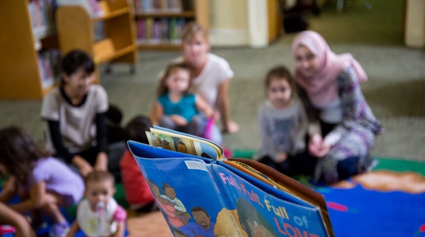 A book is read to several children and their caregivers
