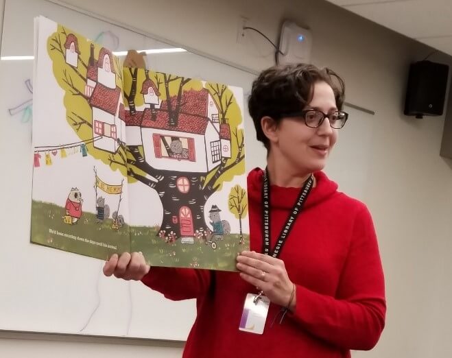 Early Learning BLAST Outreach Specialist Korie reads a book during a professional development workshop.