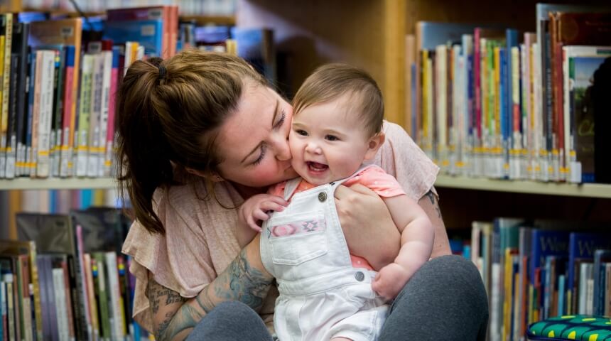 Mother kisses smiling baby in the Library