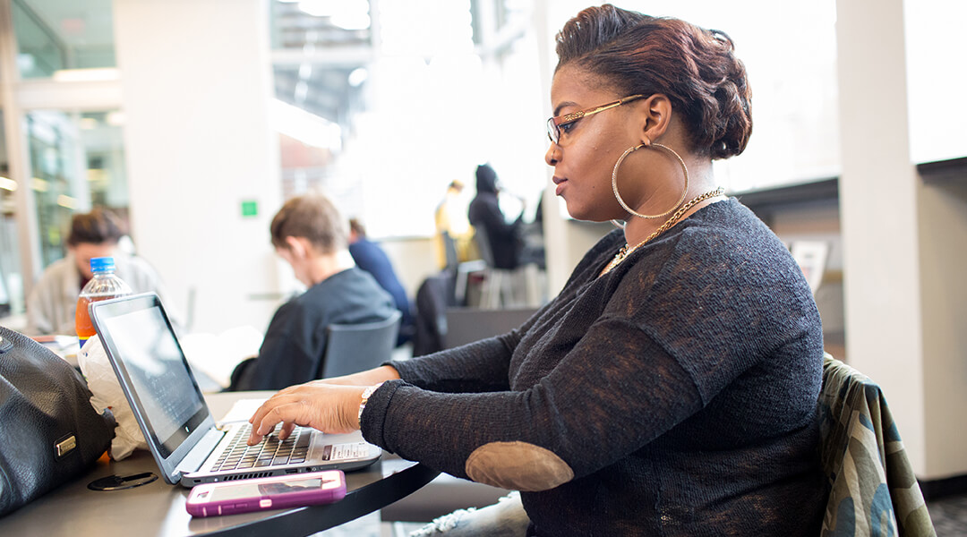 Person working on a laptop at the library.