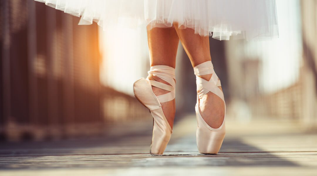 Ballerina dancing with focus on ballet slippers.