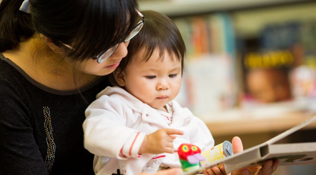 Caregiver reading to a baby.