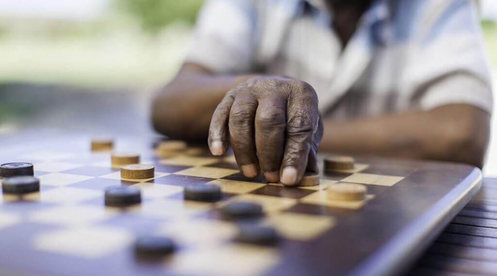 Close up of an older adult playing chess