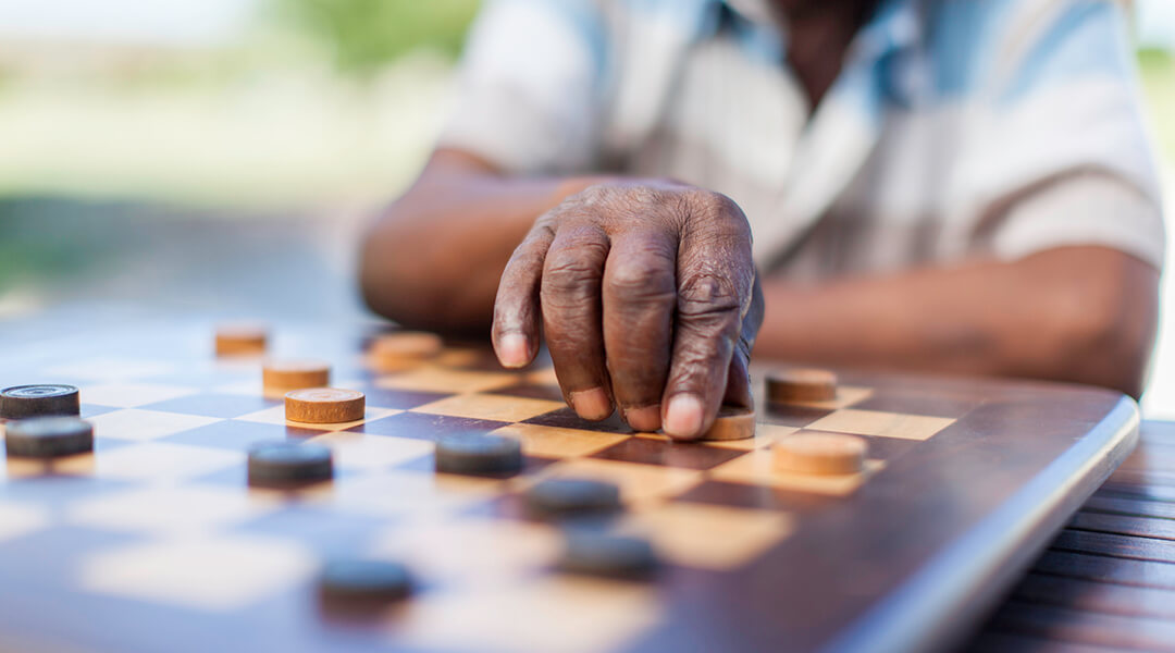 Close up of an older adult playing chess
