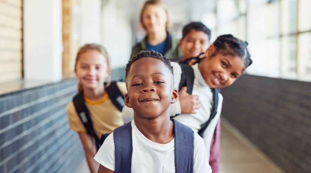 Group of school-age students wearing backpacks