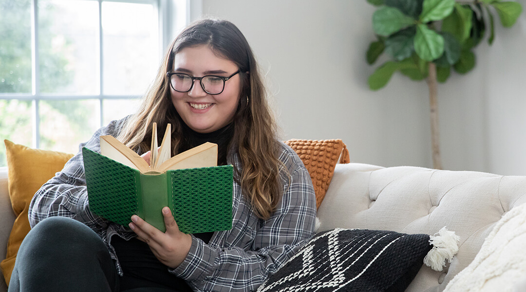 A young adult reads on the couch