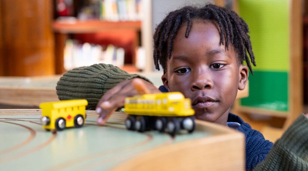 Little boy playing with train table