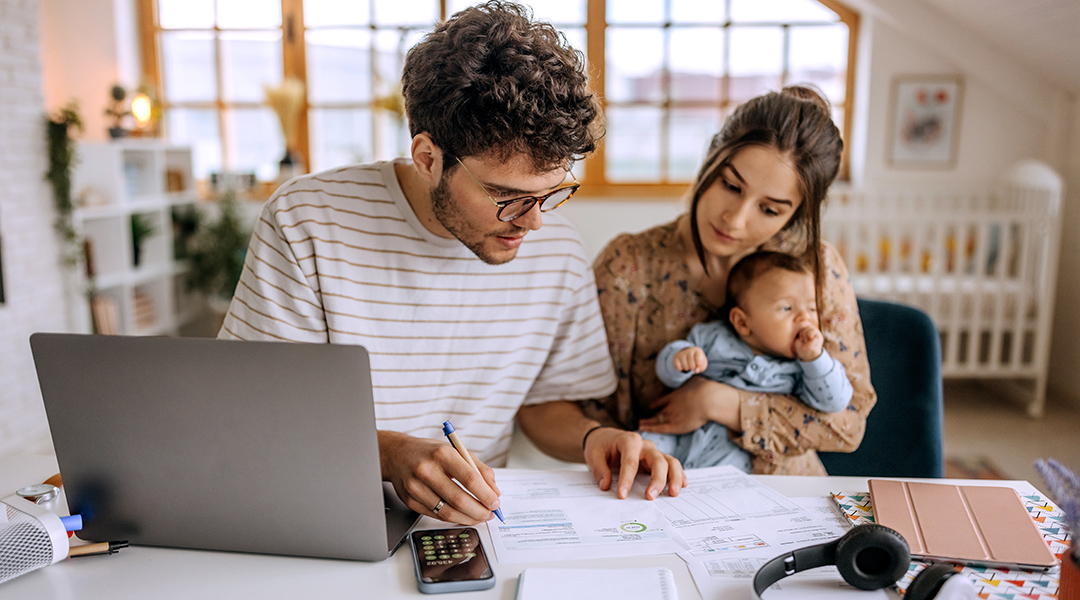 Young parents and their baby review finances together.