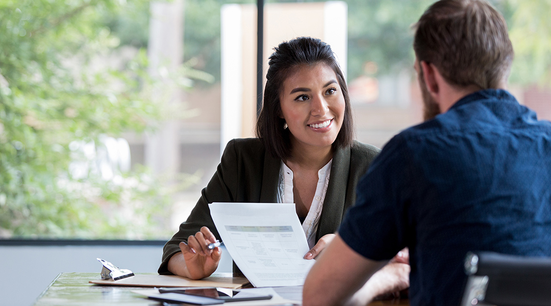 A person shares a document with another during a meeting.