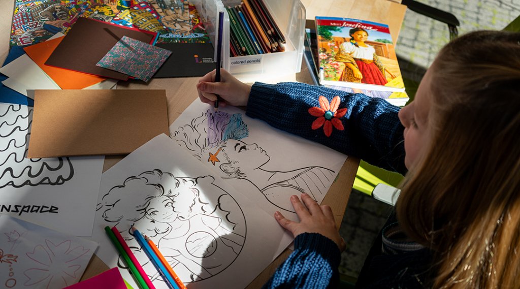 Overhead image of a child coloring in the library.