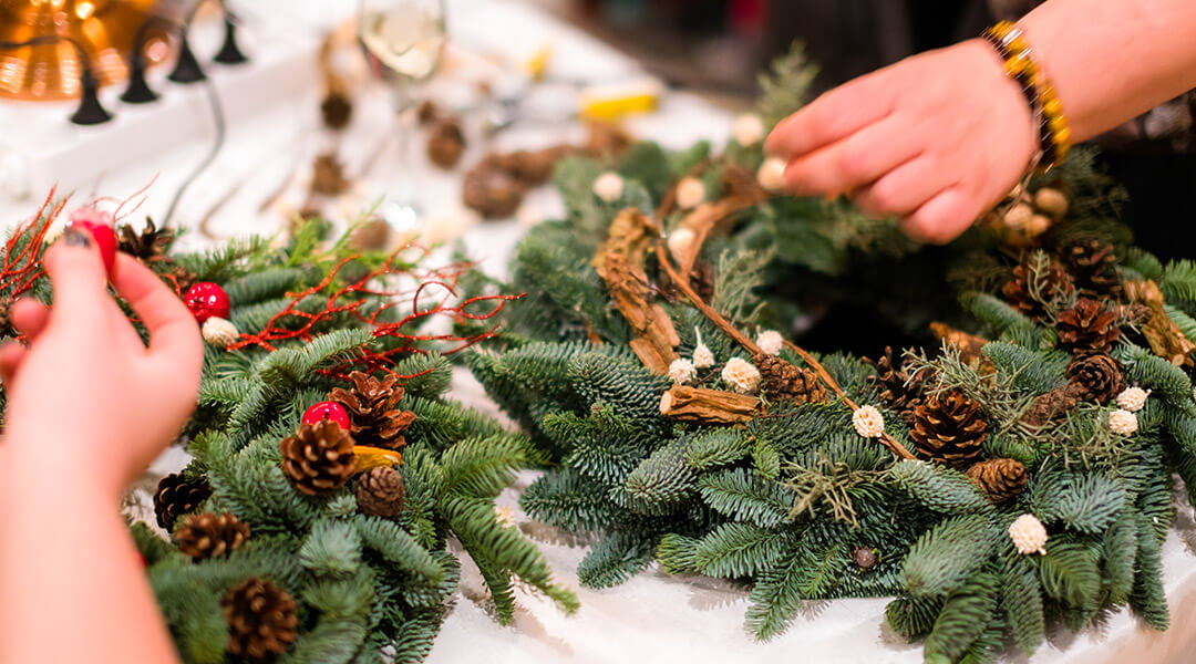 Close-up image of hands decorating a wreath.