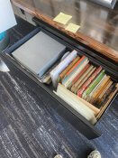 Open file cabinet drawer with books and folders.