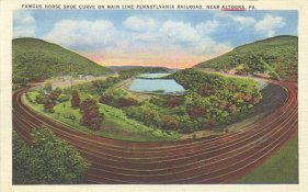 Postcard - colorized photo of a curved multi-line railroad track in a wooded landscape. It says, "Famous Horse Shoe Curve on Main Line Pennsylvania Railroad, near Altoona, PA."