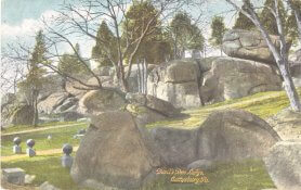 Landscape of grassy area with large boulders and rock formations