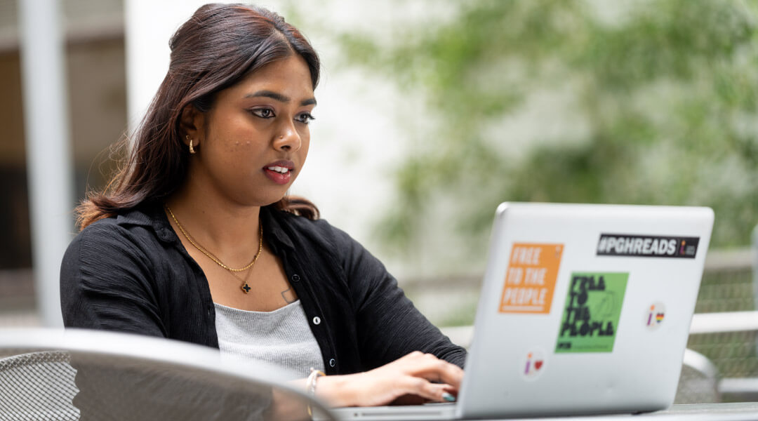 Young woman typing on a laptop in CLP - Main's Bamboo Garden