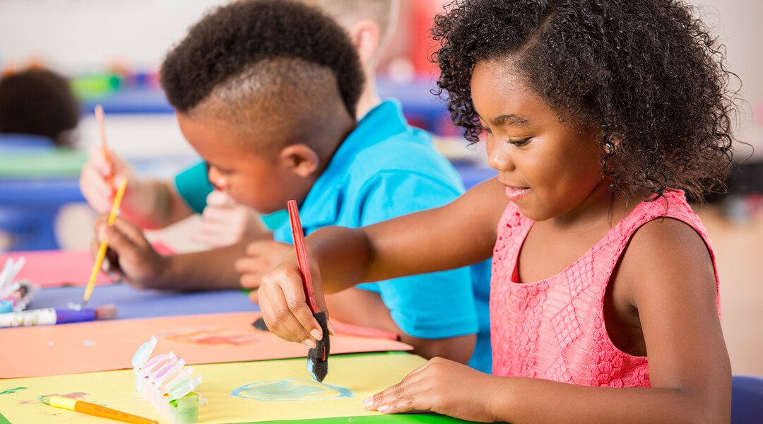 Two kindergarten student paint in class. background.