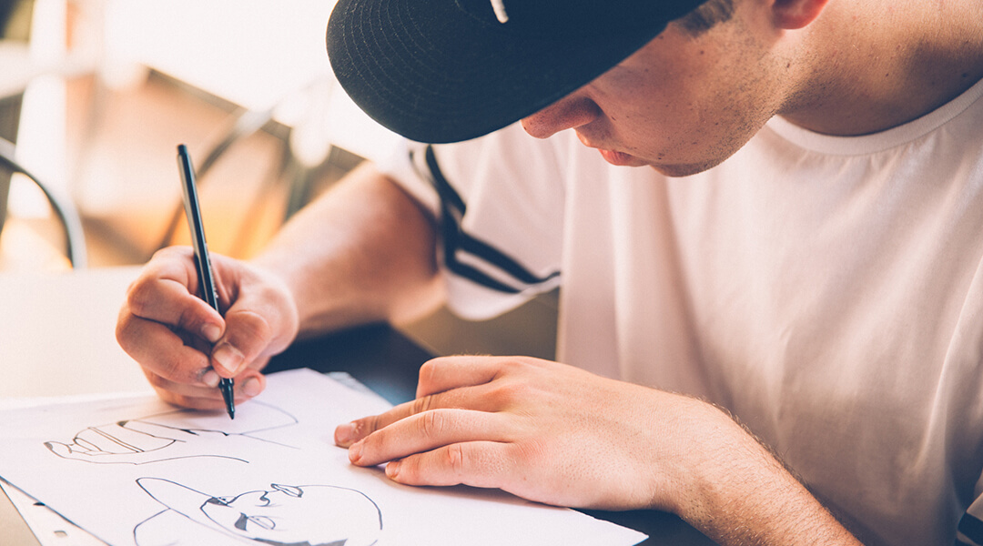 A teenaged artist makes a graffiti sketch.