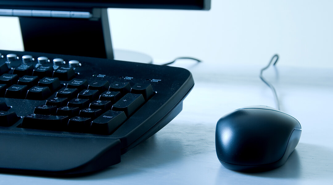 Cropped image of a computer keyboard and mouse.