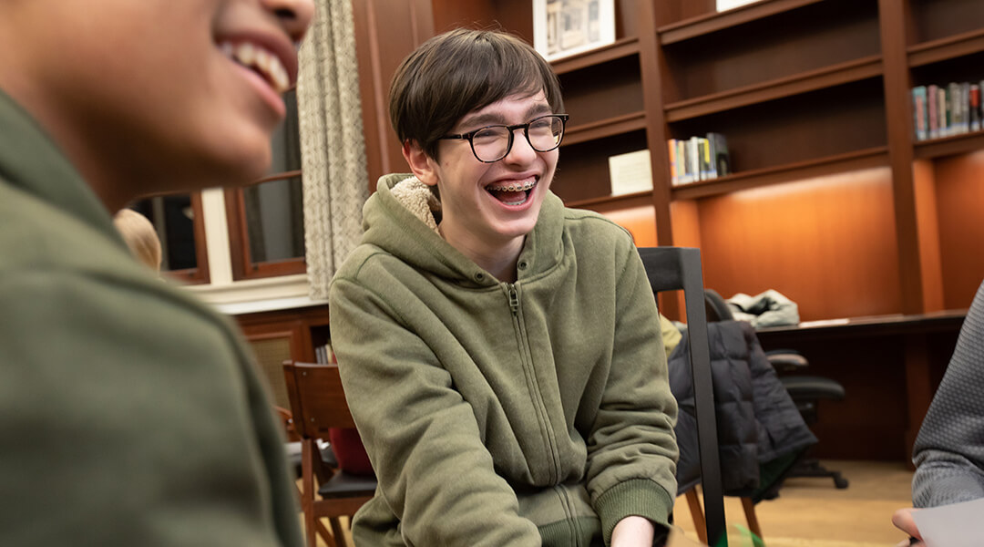 Close-crop of two teenagers laughing at a library program.